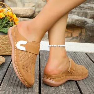 Detail of women's hollow-out mule sandals with metallic buckle and contrast stitching.