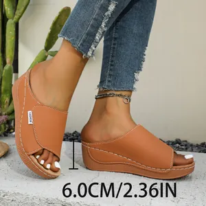 Macro view of tan wedge slides showing the 6cm heel height and stitch detail.