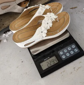 Detailed weight measurement showing single white flower wedge thong sandal at 229.4 grams