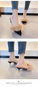 Elegant pointed-toe kitten heel mules with soft fur trim and metallic toe cap.