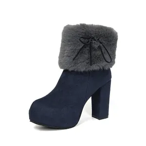 Detail view of navy blue platform ankle boots with grey faux fur collar and bow.