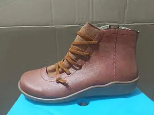 Detailed side view of women's comfortable flat brown ankle boots with lace-up design