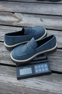 Blue chunky heel loafers shown on a digital scale for precise weight measurement