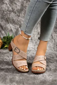 Detailed view of beige hollow-out block heel sandals with floral patterns and buckle