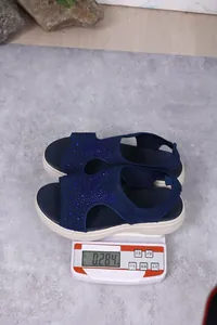 Dunkelblaue Strass-Sandalen auf einer Digitalwaage mit einem Gewicht von 0,284kg
