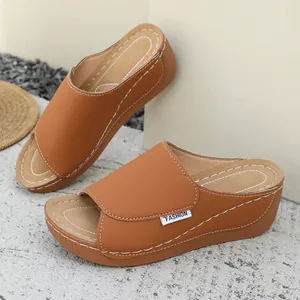 Side view of brown platform wedge sandals with peep-toe and white stitching detail
