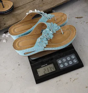 Detail showing weight of the blue floral wedge flip-flops on a digital scale