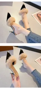 Detail of elegant black pointed-toe mules with real rabbit fur trim and metal tips.
