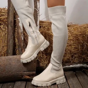 Elegant cream over-the-knee knit boots featuring a chunky lug sole and side zipper.