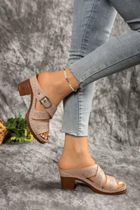 Detailed view of beige hollow-out block heel sandals featuring stylish belt buckle accent