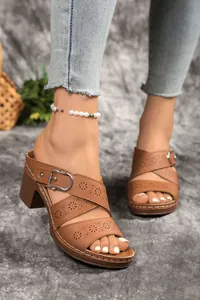 Close-up view of brown laser-cut block heel mules featuring stylish buckle accents for women