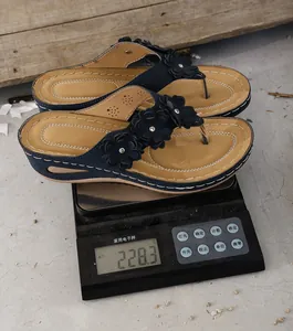 Dark blue wedge flower thong sandals weighing approximately 228 grams on a scale