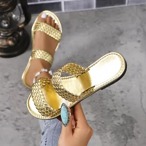 Detailopname van stijlvolle gouden geweven sandalen met dubbele band voor dames in de zomer