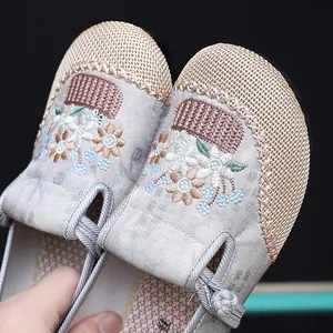 Macro detail of delicate floral embroidery on traditional Chinese ethnic style cloth shoes