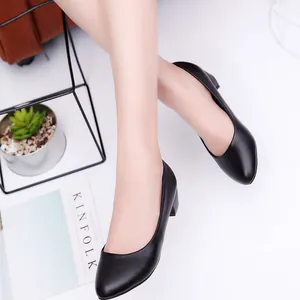 Close-up of black round-toe pumps with stable block heels for professional office wear.