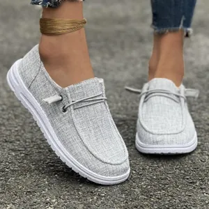 Close-up detail of comfortable gray canvas slip-on loafers for women on outdoor path
