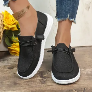 Detailed close-up view of women's black casual canvas loafers with white rubber soles