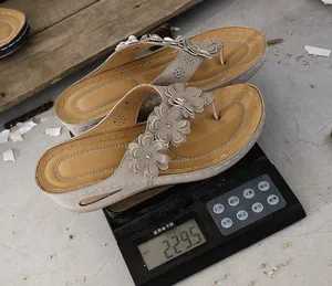 Macro view of stylish lightweight wedge flip flops with flower detail weighing 229.5g