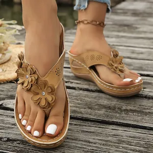 Vista detallada de sandalias con cuña marrones para mujer con flores y elegantes costuras blancas