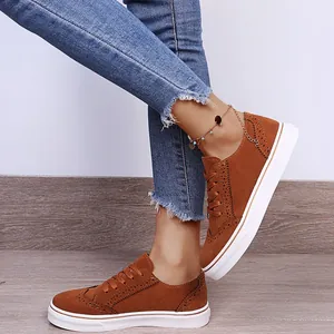 Detailaufnahme brauner Wildleder-Brogues mit weißer Plateausohle und Schnürung.