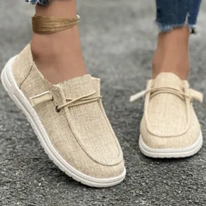 Macro view of beige canvas women's loafers showing natural fabric texture and stitching