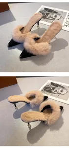 Close-up of pointed-toe high heel slippers with lush real rabbit fur and metal cap