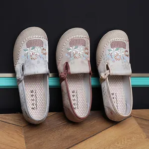 Close-up view of three colors of traditional Chinese ethnic style floral embroidered cloth shoes