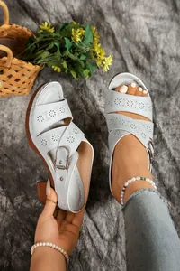 Close-up of light blue cut-out block heel sandals with silver buckle detail