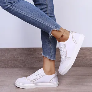 Detailansicht weißer Damenschuhe mit eleganter Brogue-Schnitzerei und weicher Sohle
