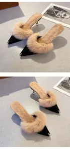 Elegant black pointed toe mules with fluffy tan fur trim and metal toe caps