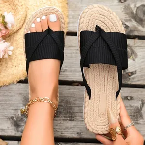 Detail view of women's black fabric thong sandals with summer straw-textured soles