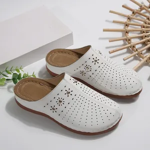 Detailweergave van witte platform slippers voor dames met bloemenperforaties