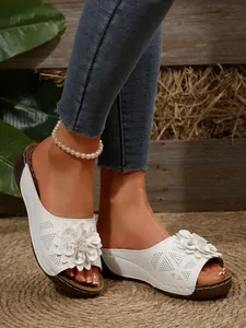 Close-up of white floral wedge sandals with platform sole and open-toe design