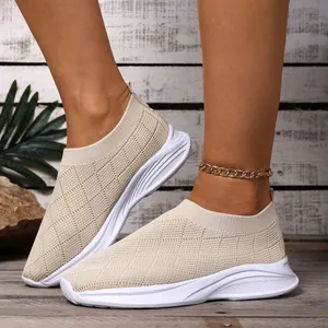 Vista dettagliata delle scarpe slip-on in maglia beige traspirante con suola bianca