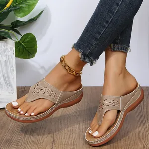 Detalle de sandalias de cuña para mujer con diseño calado y pedrería para un estilo casual.