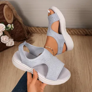 Nahaufnahme hellblauer Mesh-Sandalen mit Peeptoe-Design und funkelnden Strasssteinen.