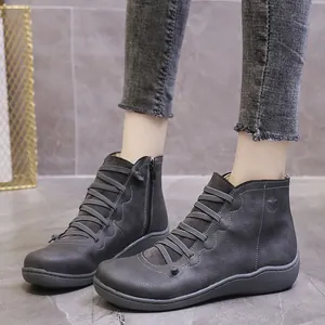 Detail showing the grey casual ankle boots with cross-lace design and side zipper.