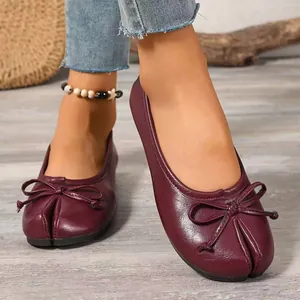 Close-up of elegant burgundy flat shoes with bow and unique split-toe stitch detail