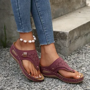 Detail view of purple wedge thong sandals with hollow patterns and thick sole