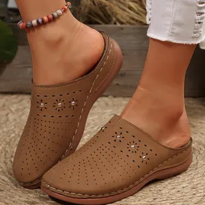 Detailed view of women's brown closed-toe platform slides with perforated floral patterns