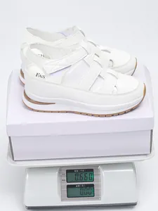Detailed shot of white wedge platform sandals on scale weighing 0.66kg with box