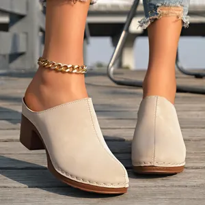 Mules beiges à talons carrés et bout fermé pour femmes dans un cadre naturel.