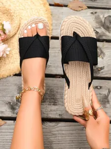 Detail showing the soft imitation straw texture and black straps of the beach slippers.