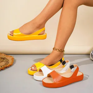 Primer plano de cómodas sandalias de plataforma peep-toe en amarillo, blanco y naranja.