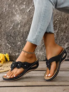 Stylish black wedge flip-flop sandals for women featuring elegant flower details on feet