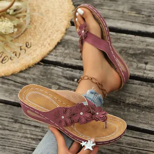 Primer plano de sandalias con cuña burdeos con flores decorativas y elegantes diamantes de imitación