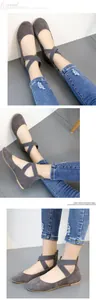 Close-up of grey round-toe ballet flats with elastic cross straps and rear zipper