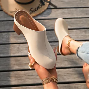 Gros plan de mule beige à bout fermé avec un talon épais et une couture centrale