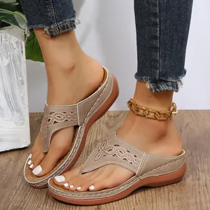 Detalle de sandalias de cuña para mujer con elegantes patrones calados y pedrería fina