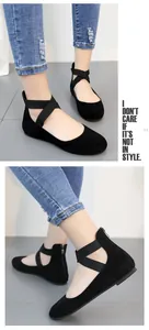 Detailed view of black suede ballet flats with elastic cross-straps and back zipper.